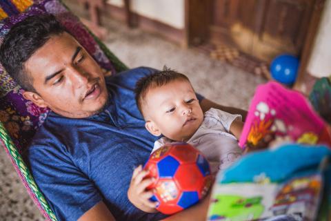 <start> a man and a boy are playing with a ball <end>